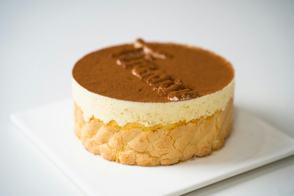 Close-up of a delectable tiramisu cake with creamy layers and cocoa dusting.