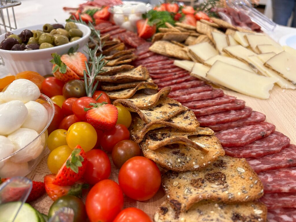 A vibrant charcuterie board featuring cheese, meats, crackers, and fresh fruits.