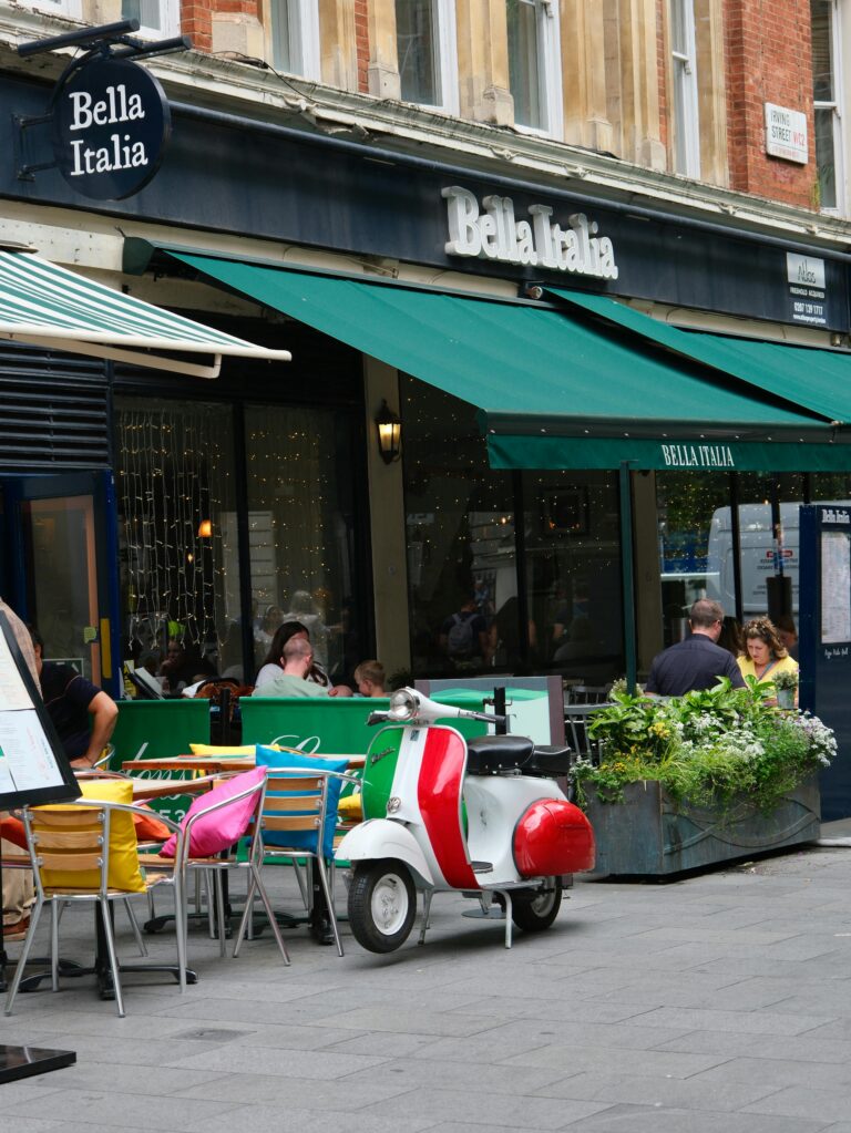 Charming al fresco dining at Bella Italia with Vespa parked outside in London.