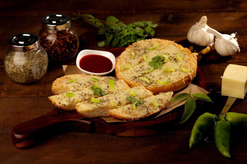 Tasty garlic bread topped with herbs and cheese, garnished with fresh ingredients.