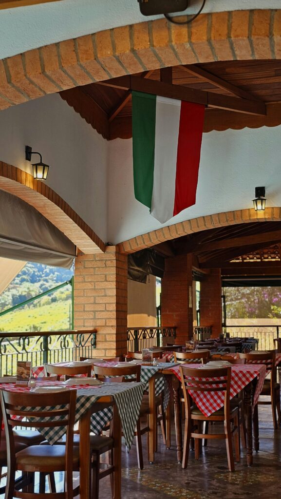 Cozy Italian restaurant with a flag, wooden decor, and scenic outdoor view.